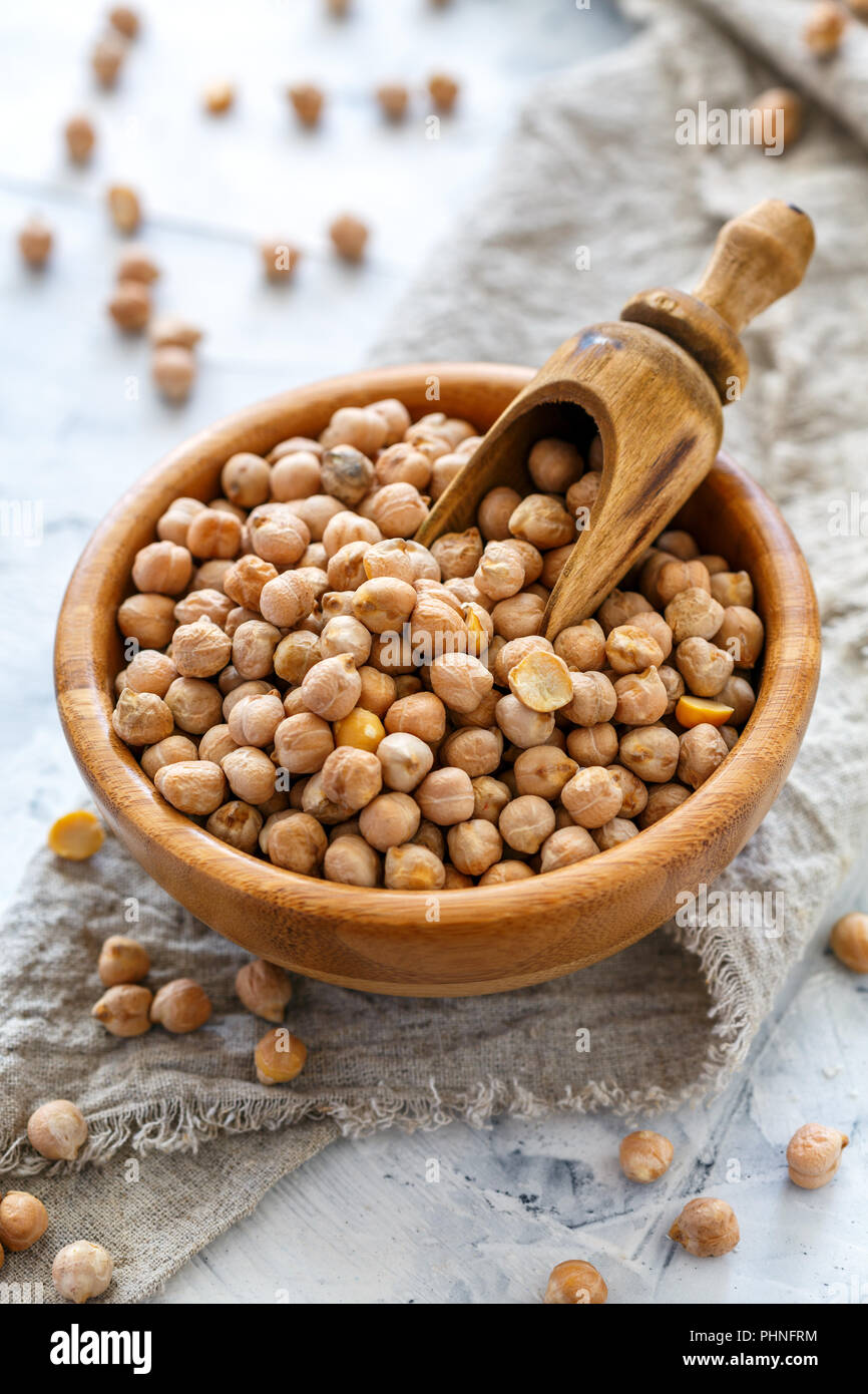 Organic chickpeas in bowl on white table. Stock Photo