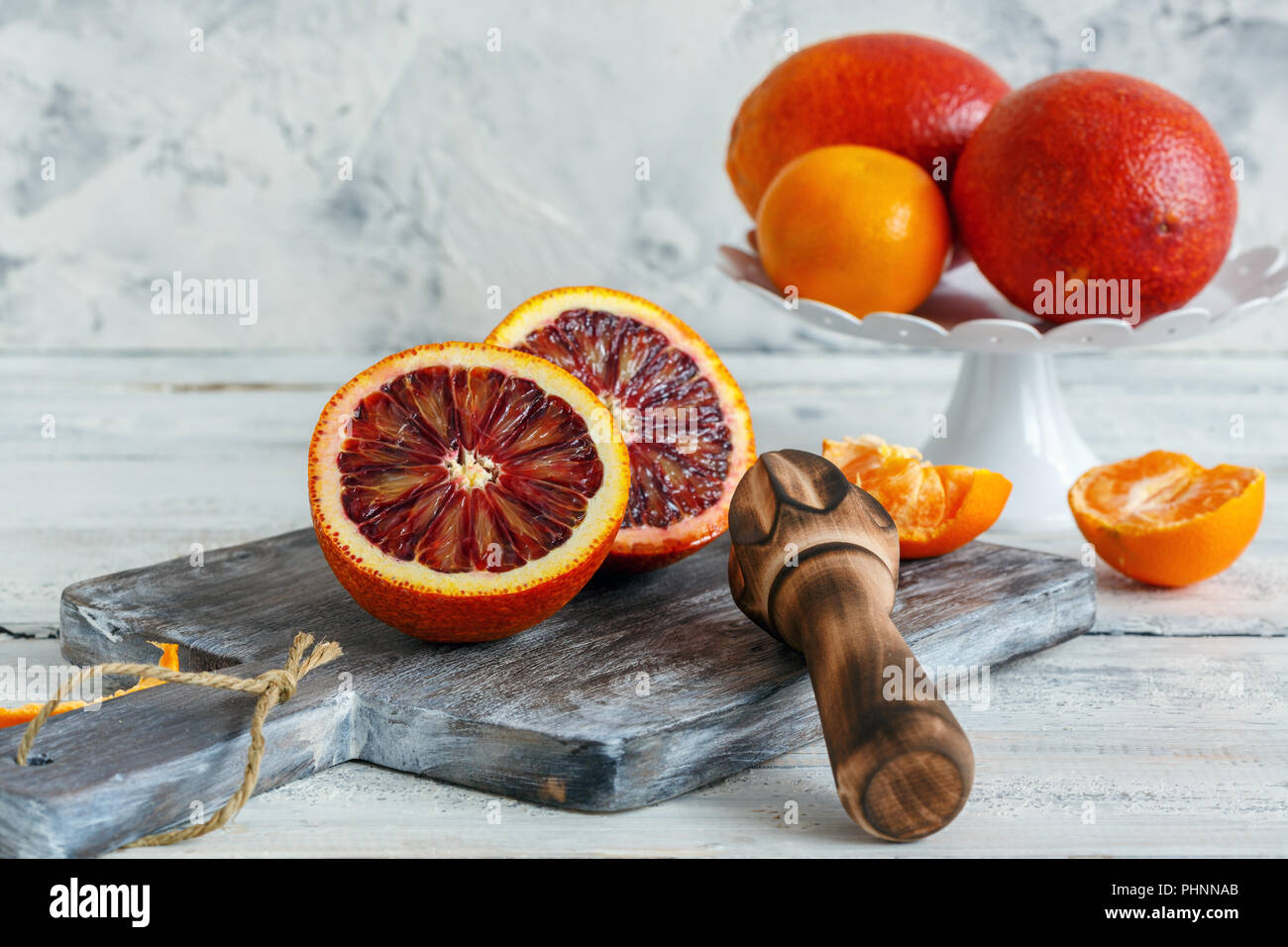 Blood orange cut in half and wooden citrus press. Stock Photo