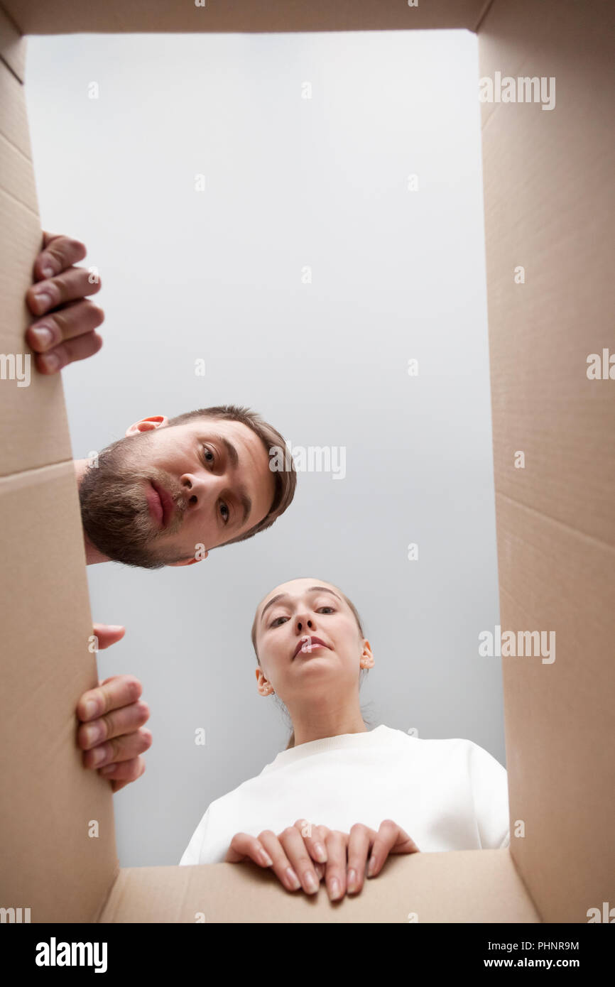Frustrated couple looking inside parcel disappointed with order Stock Photo