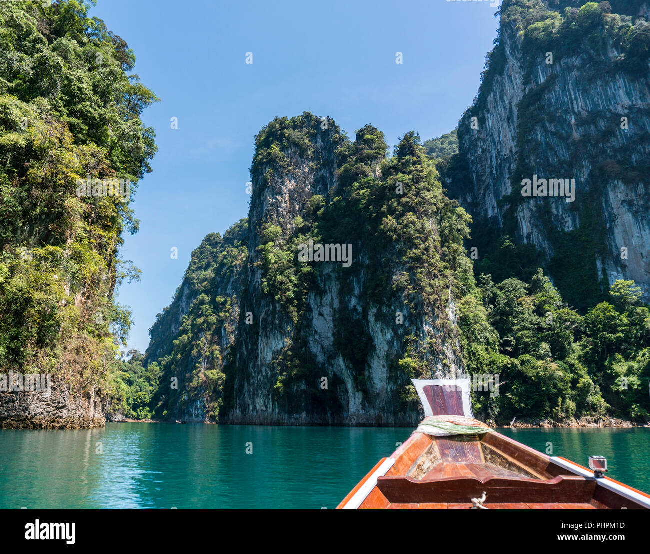 Wooden Thai traditional longtail boat on a lake with mountains and
