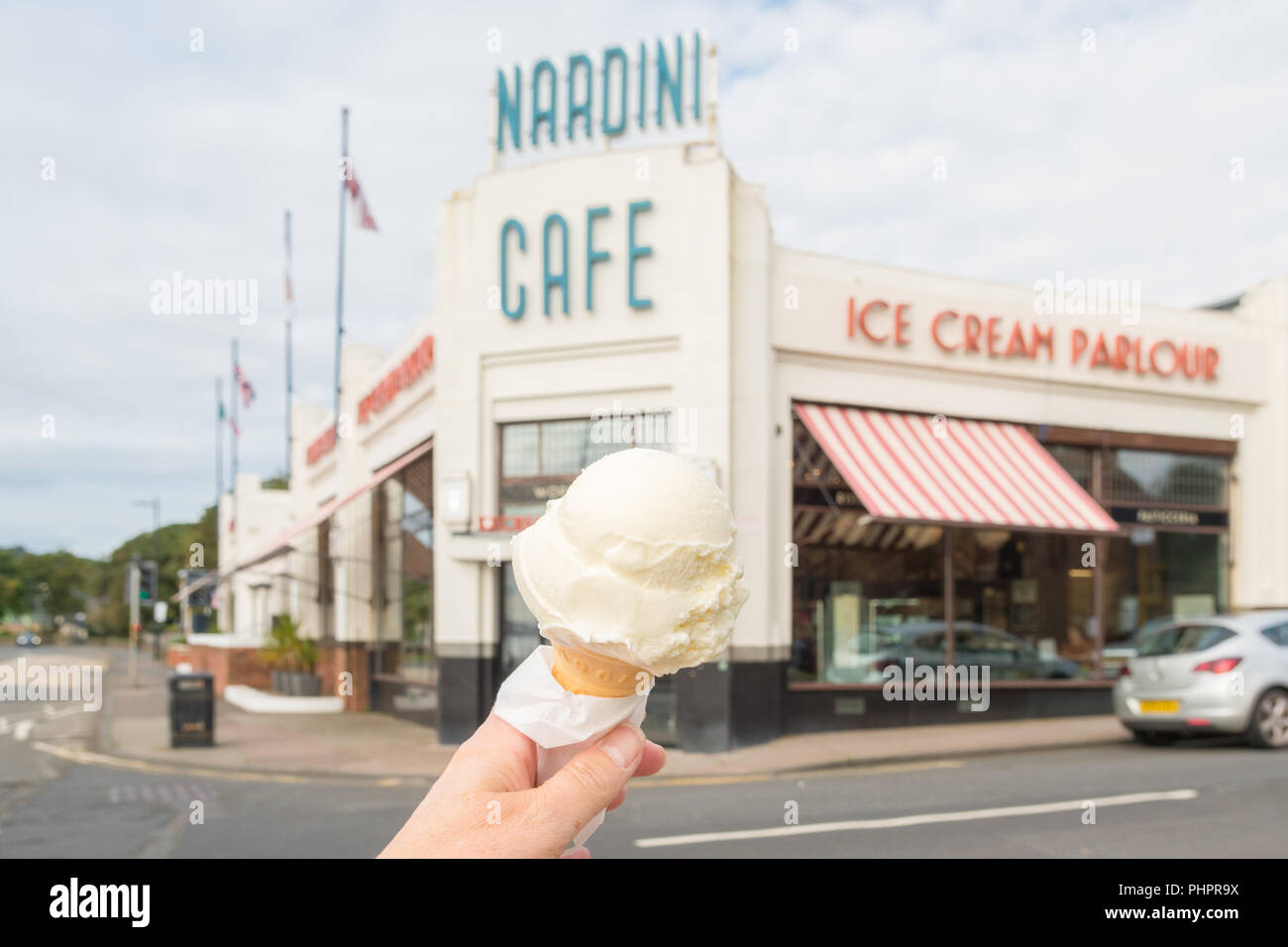 hand holding Nardinis ice cream cone outside Nardini Cafe and ice cream parlour, Largs, Scotland, UK Stock Photo