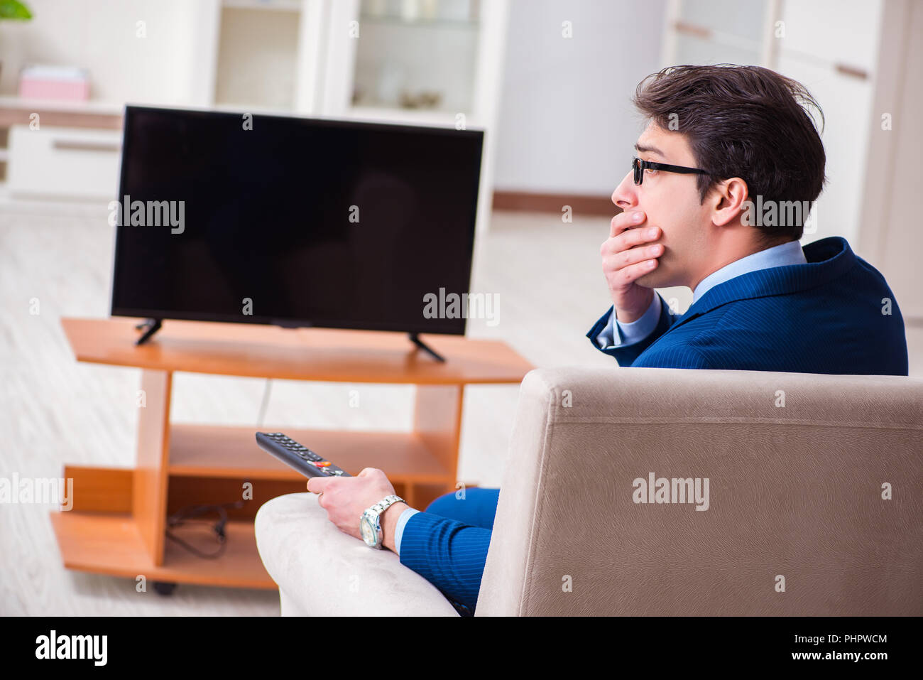 Businesman watching tv in office Stock Photo Alamy