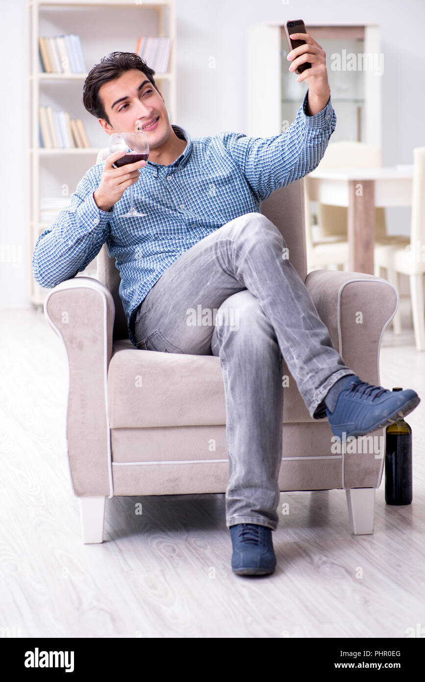 Young man drinking wine at home Stock Photo - Alamy