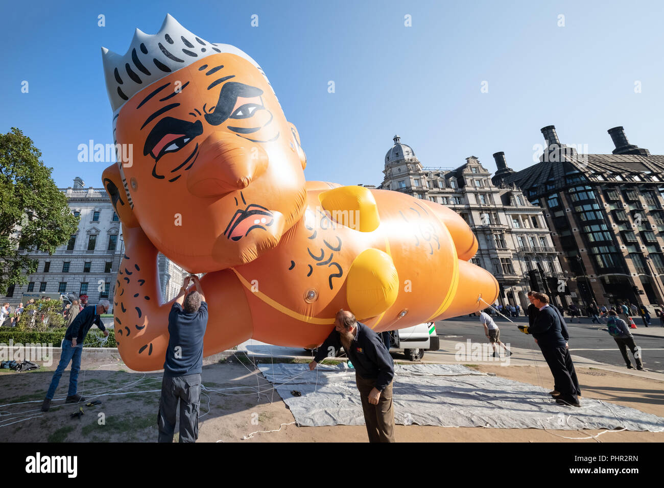 Giant blimp of London Mayor Sadiq Khan wearing a yellow bikini is inflated ready to fly over Parliament square in London, UK. Stock Photo