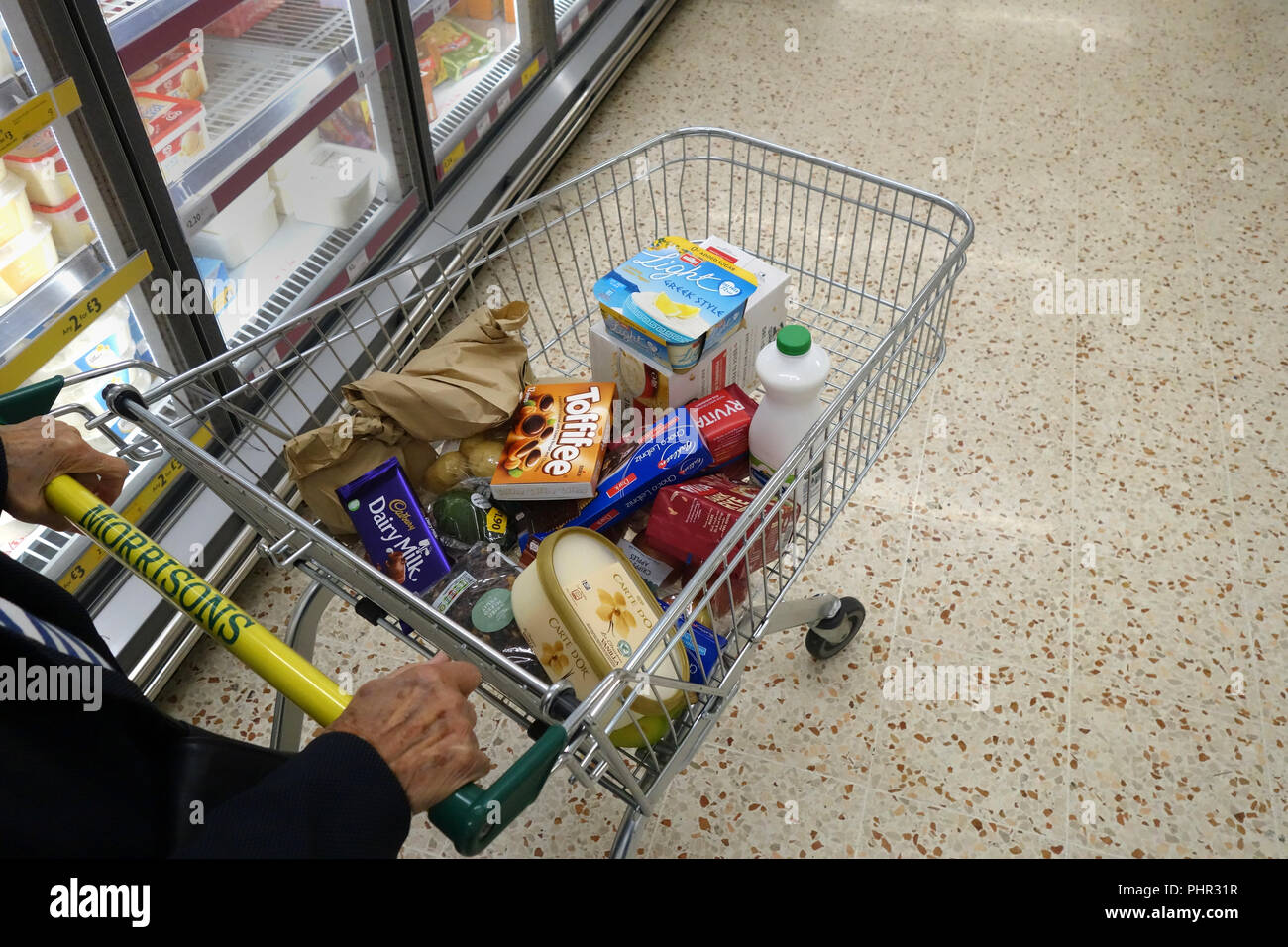 Elderly lady supermarket shopping at Morrisons supermarket aisle