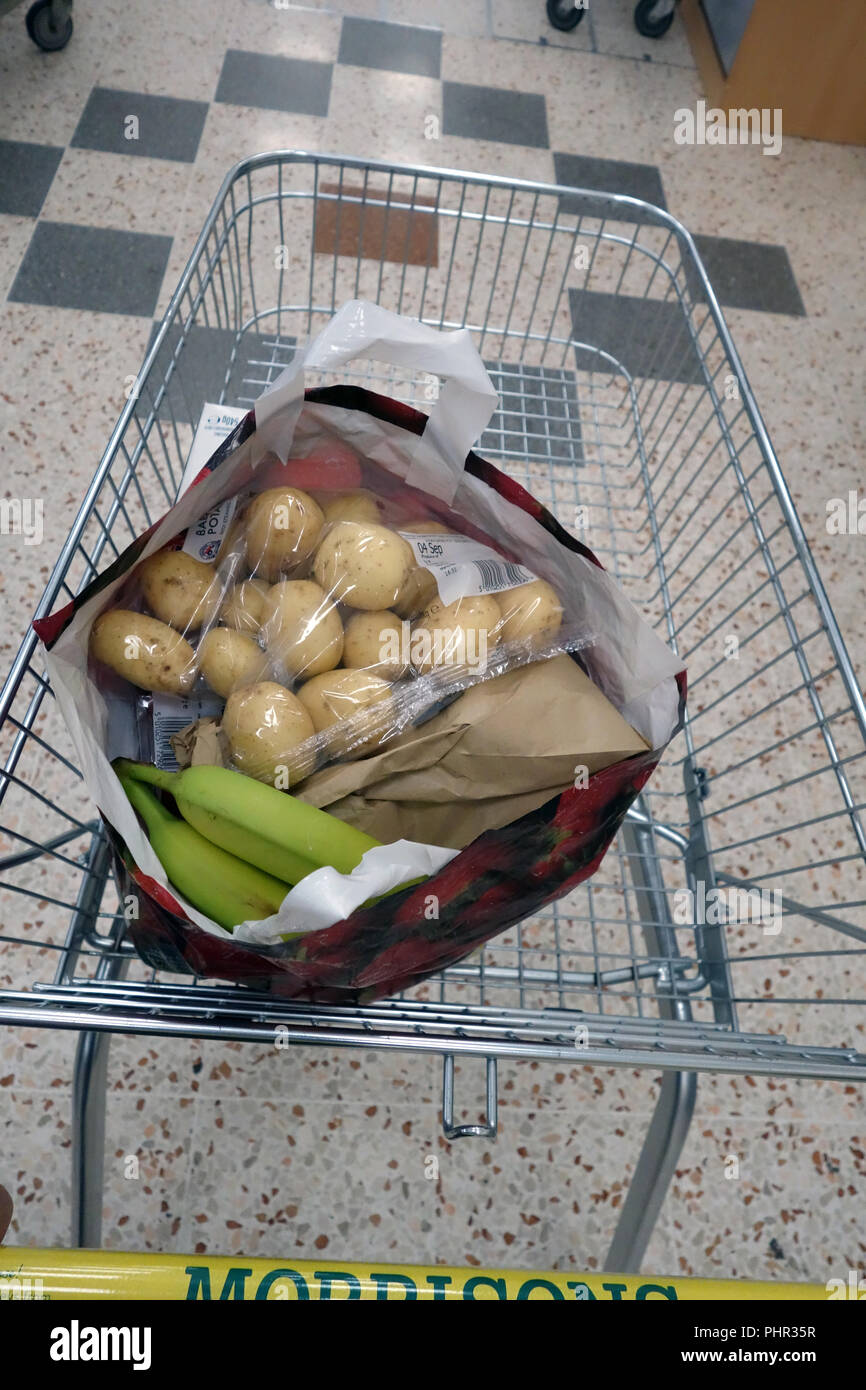 birds eye view into a full shopping bag in a trolley of paid for items from shopping at Morrisons, Halfway, Sheffield, England Stock Photo
