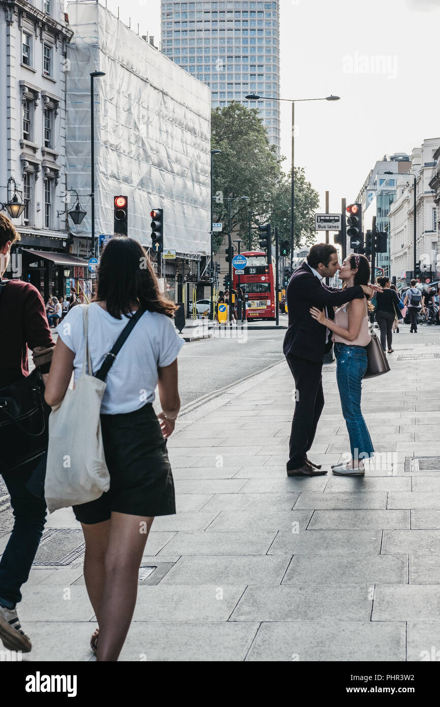 London, UK - July 24, 2018: People kissing in front of passers by on Oxford street, London, one of the most famous streets in the city. Stock Photo