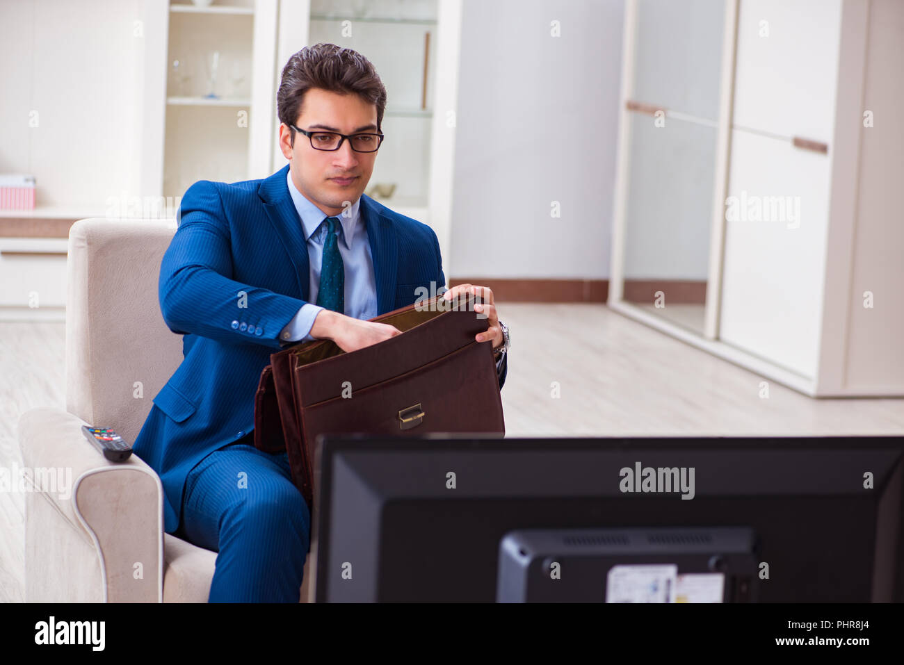 Businesman watching tv in office Stock Photo Alamy