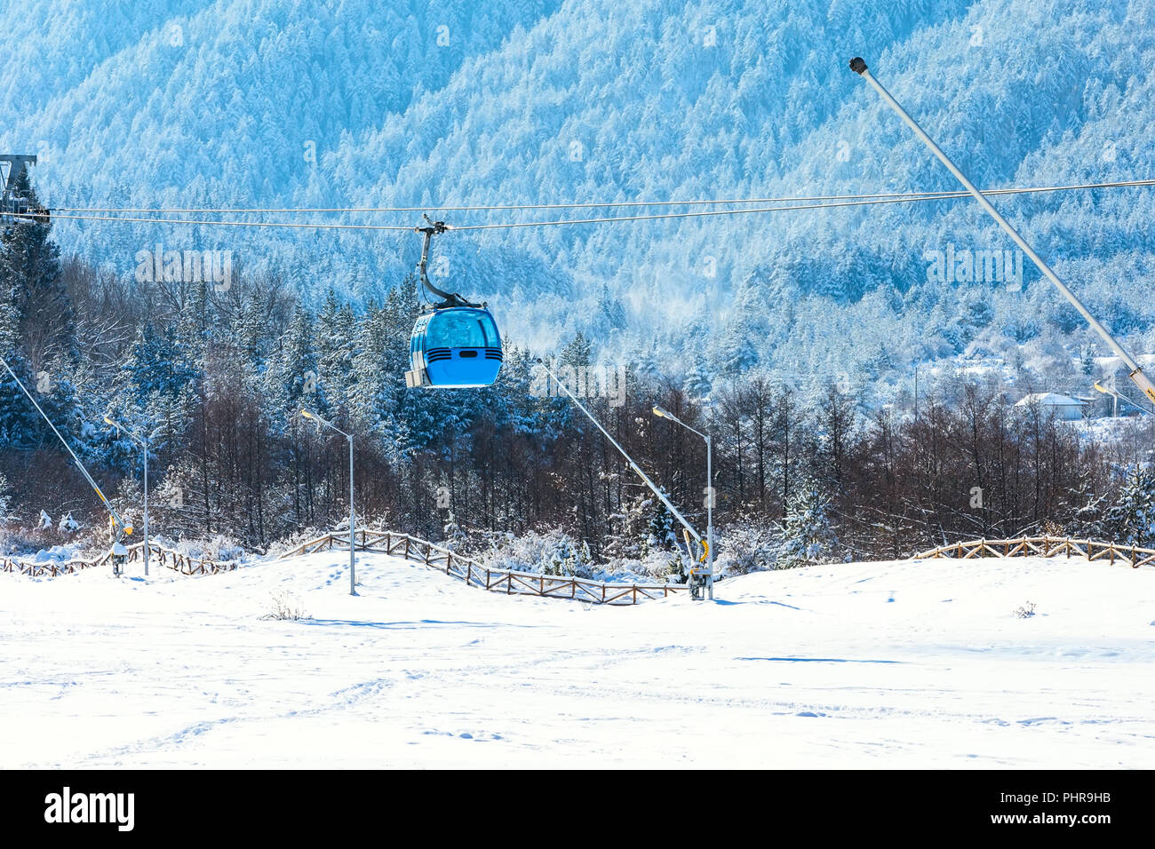 Blue cable car cabin ski lift and snow mountain pine trees at the ...