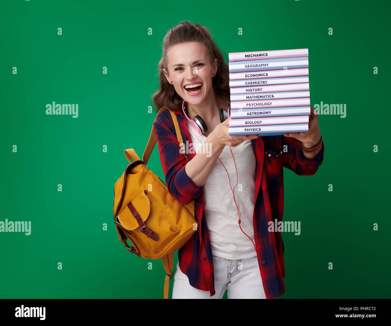 happy modern student woman in a red shirt with backpack and headphones ...
