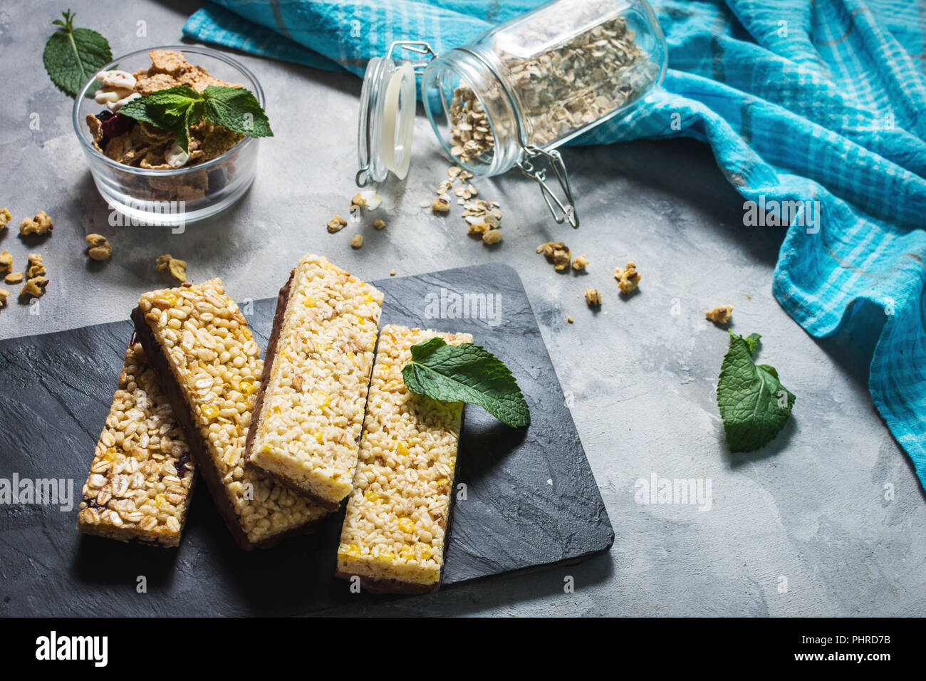 Granola energy bars with oatmeal, almond, dry cranberry. Healthy snack on concrete background. Stock Photo