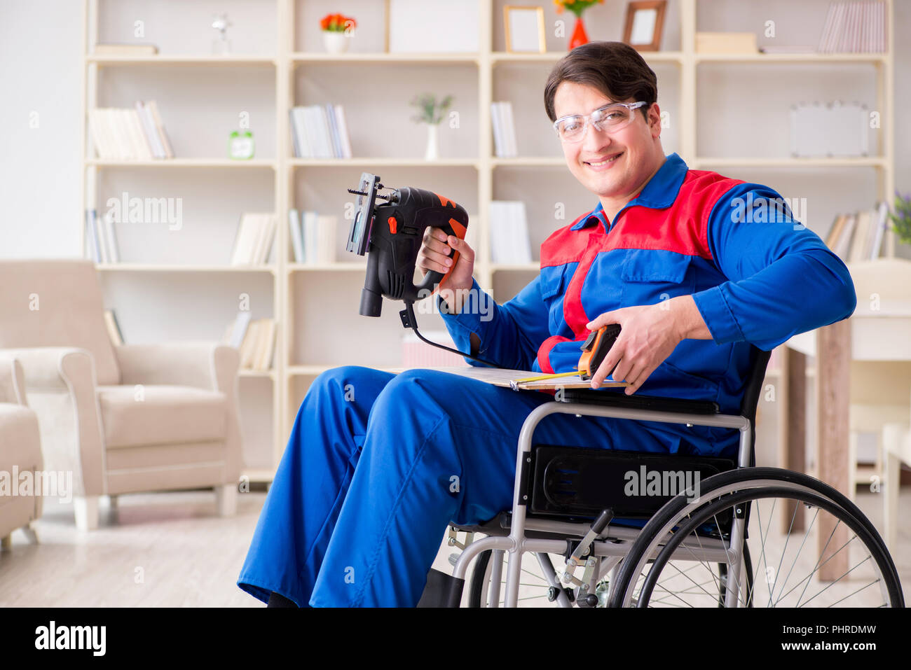 Disabled man working with handsaw at home Stock Photo