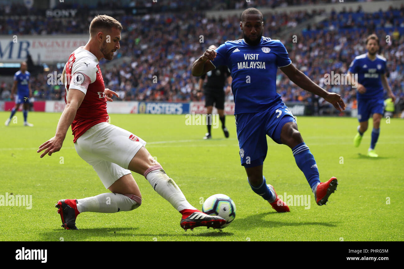 Arsenal's Aaron Ramsey (left) and Cardiff City's Junior Hoilett battle for the ball during the Premier League match at the Cardiff City Stadium. Stock Photo