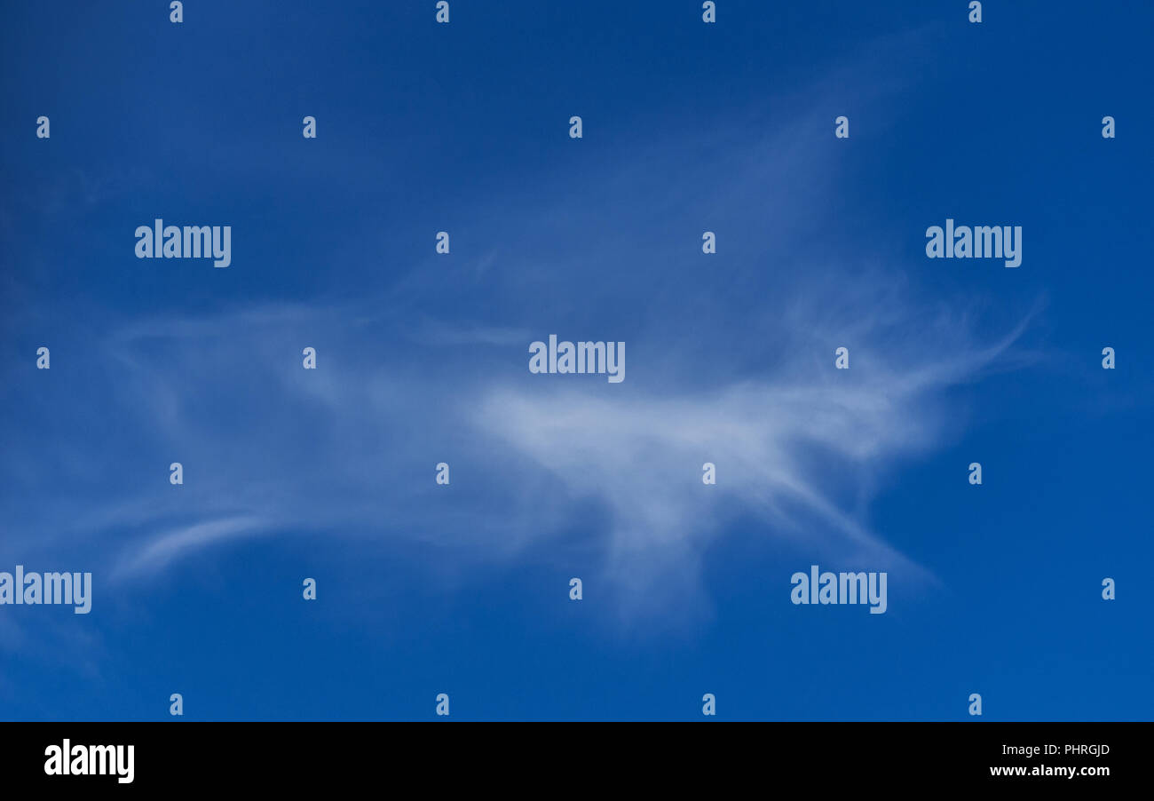Fantasy Imagination Concept: Running Unicorn Shape White Cloud on Blue Sky Background. Stock Photo