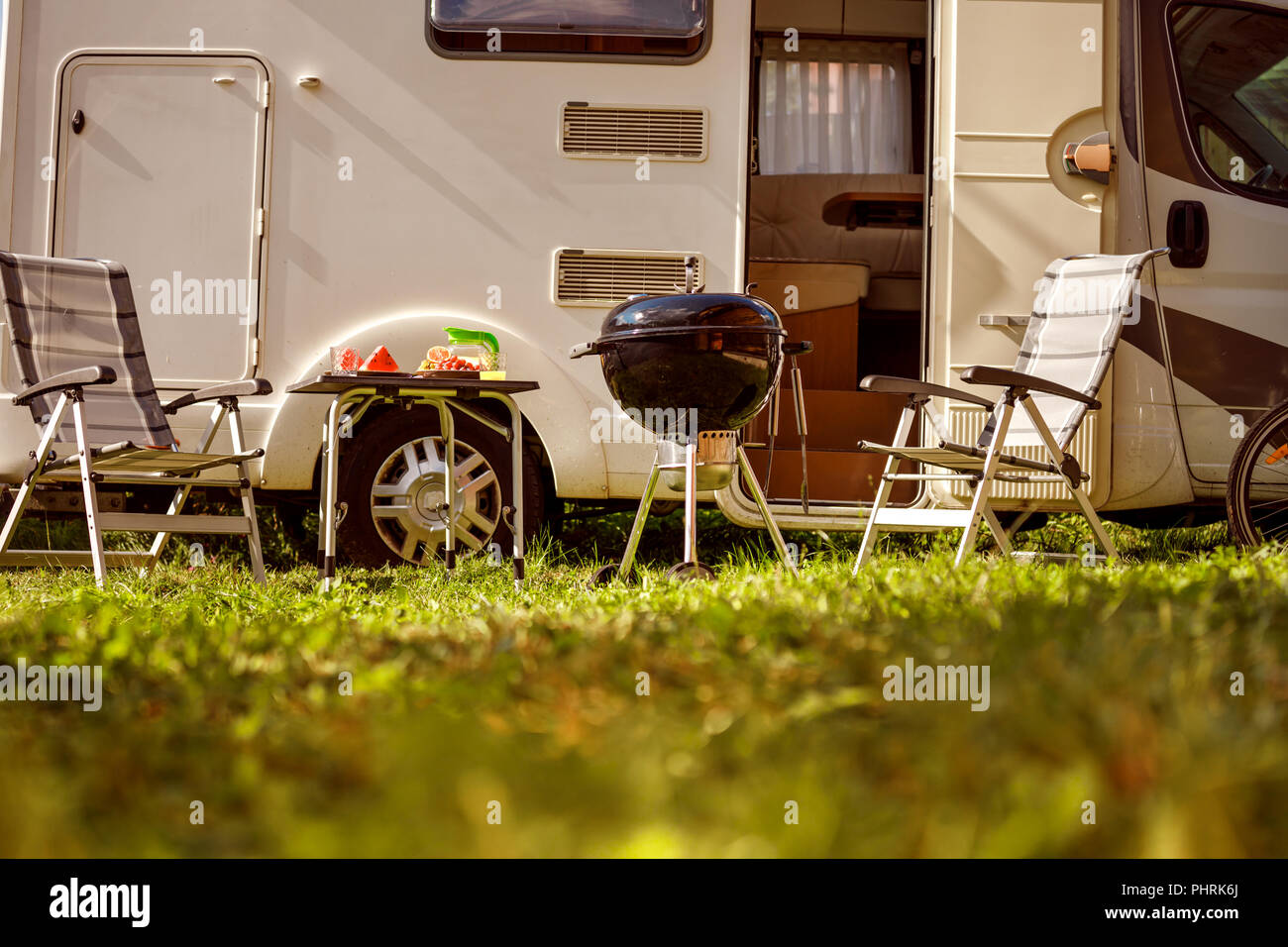 Family vacation travel RV, holiday trip in motorhome, Caravan car Vacation. Picnic with outdoor barbecue. Stock Photo