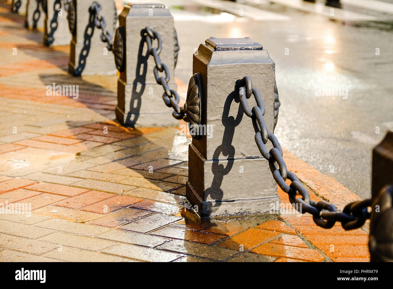 Fence with chains. Chain fence in the background of the road. paving