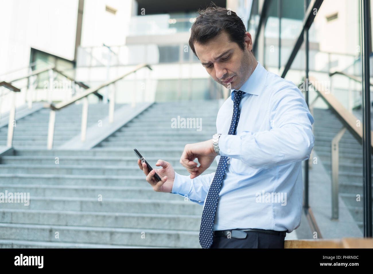 Busy Businessman Checking The Time On His Wristwatch Stock Photo Alamy