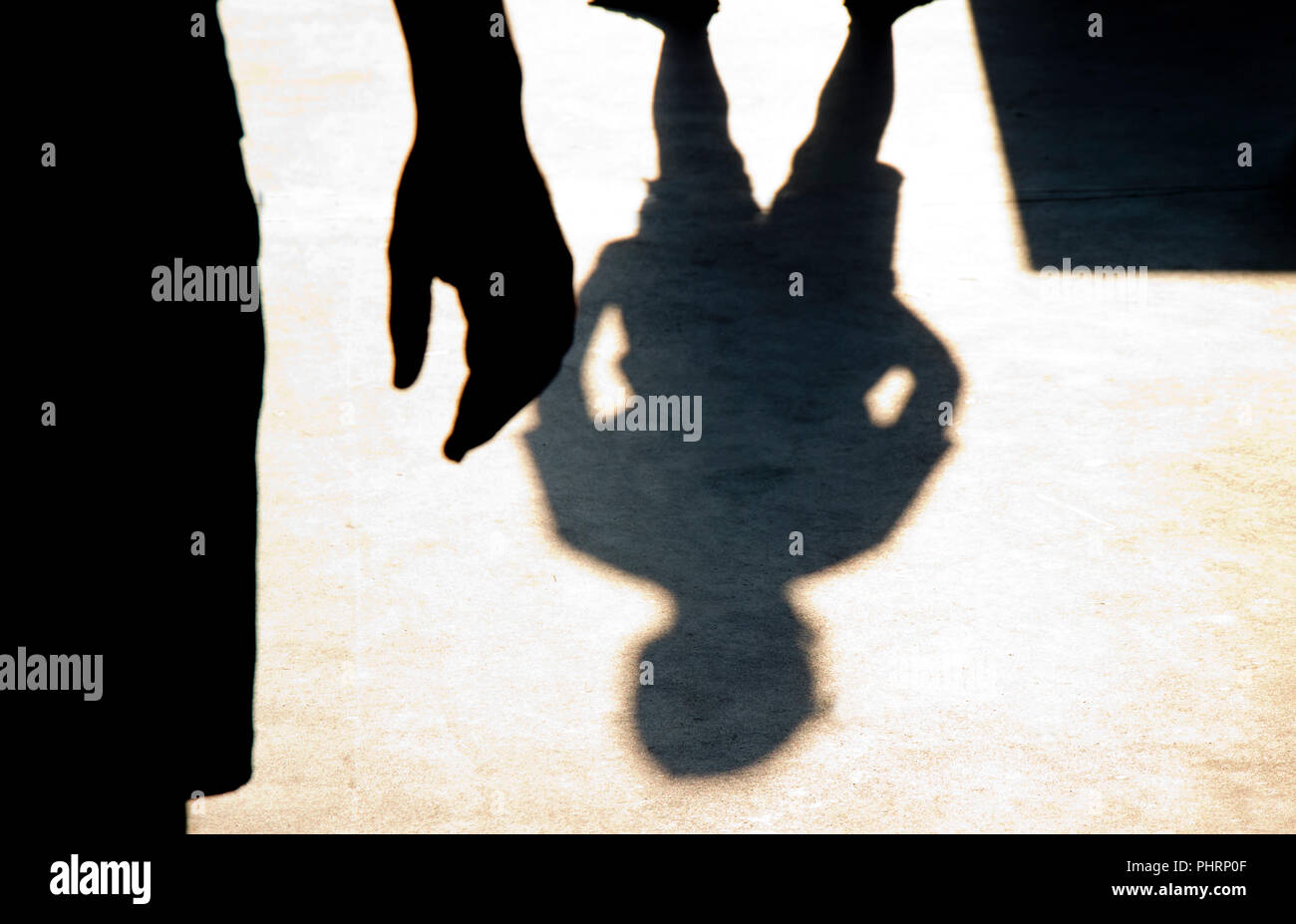 Blurry shadow silhouette of two boys confronting each other in school yard Stock Photo