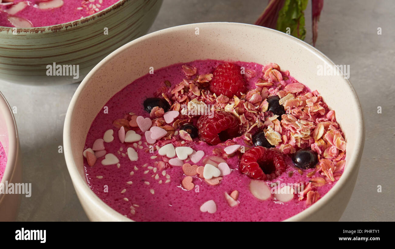 Bowl with breakfast pink smoothie from granola and almond. Stock Photo