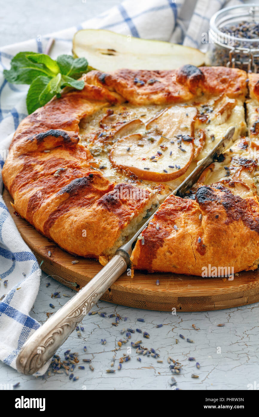 Cut free-form cake (Galette) with pear and lavender. Stock Photo