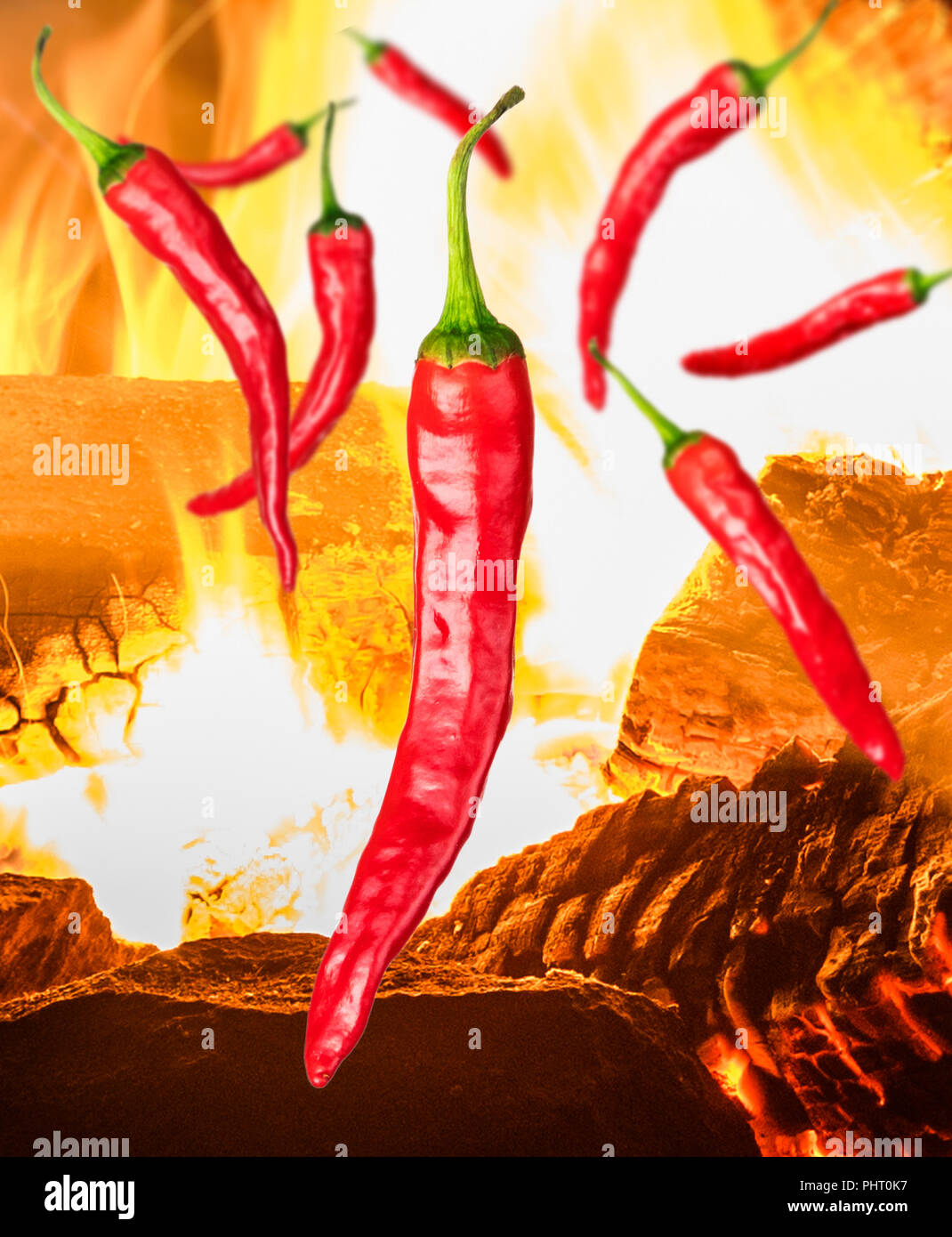 a few pieces of red chili peppers on background with fire Stock Photo