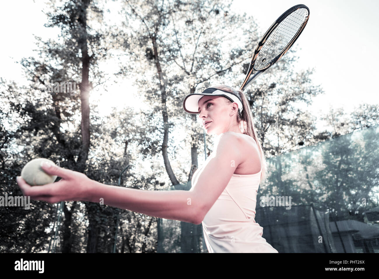 Focused beautiful female player improving tennis technique Stock Photo