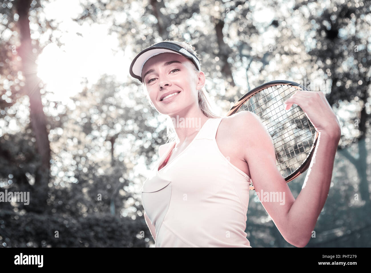 Jolly gay female player enjoying tennis game Stock Photo