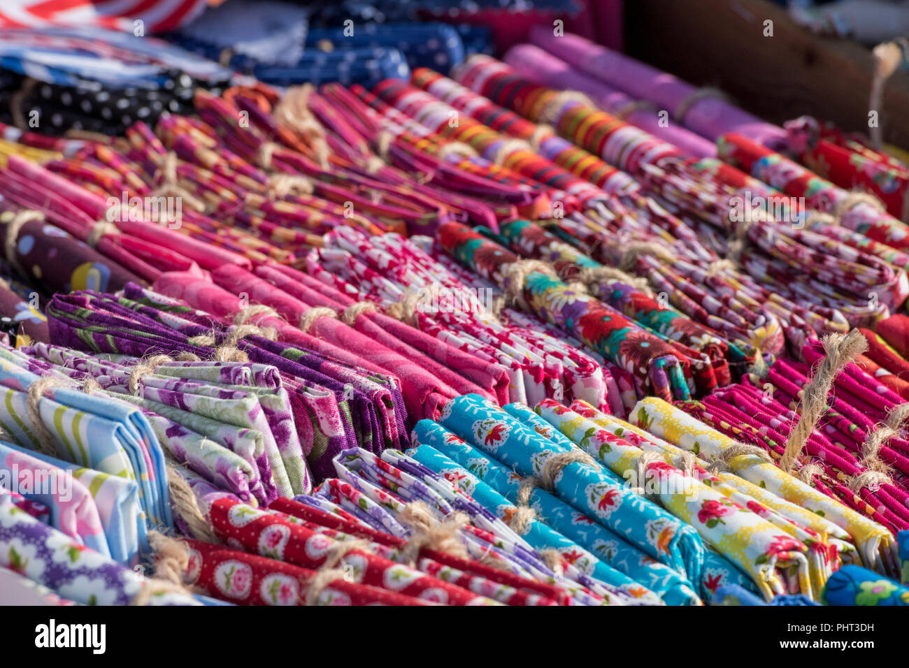 a selection of multicoloured linen or cotton throws and cloths on sale