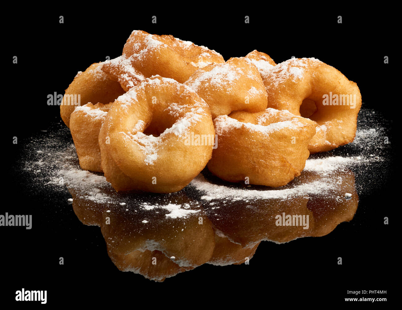 Heap of donuts with sugar powder on black reflective background Stock Photo