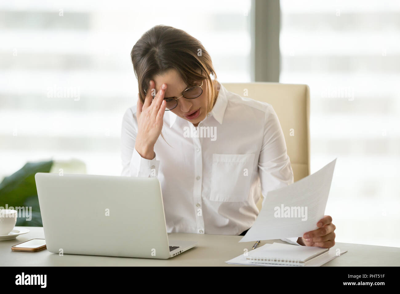 Frustrated upset businesswoman holding dismissal notice shocked  Stock Photo