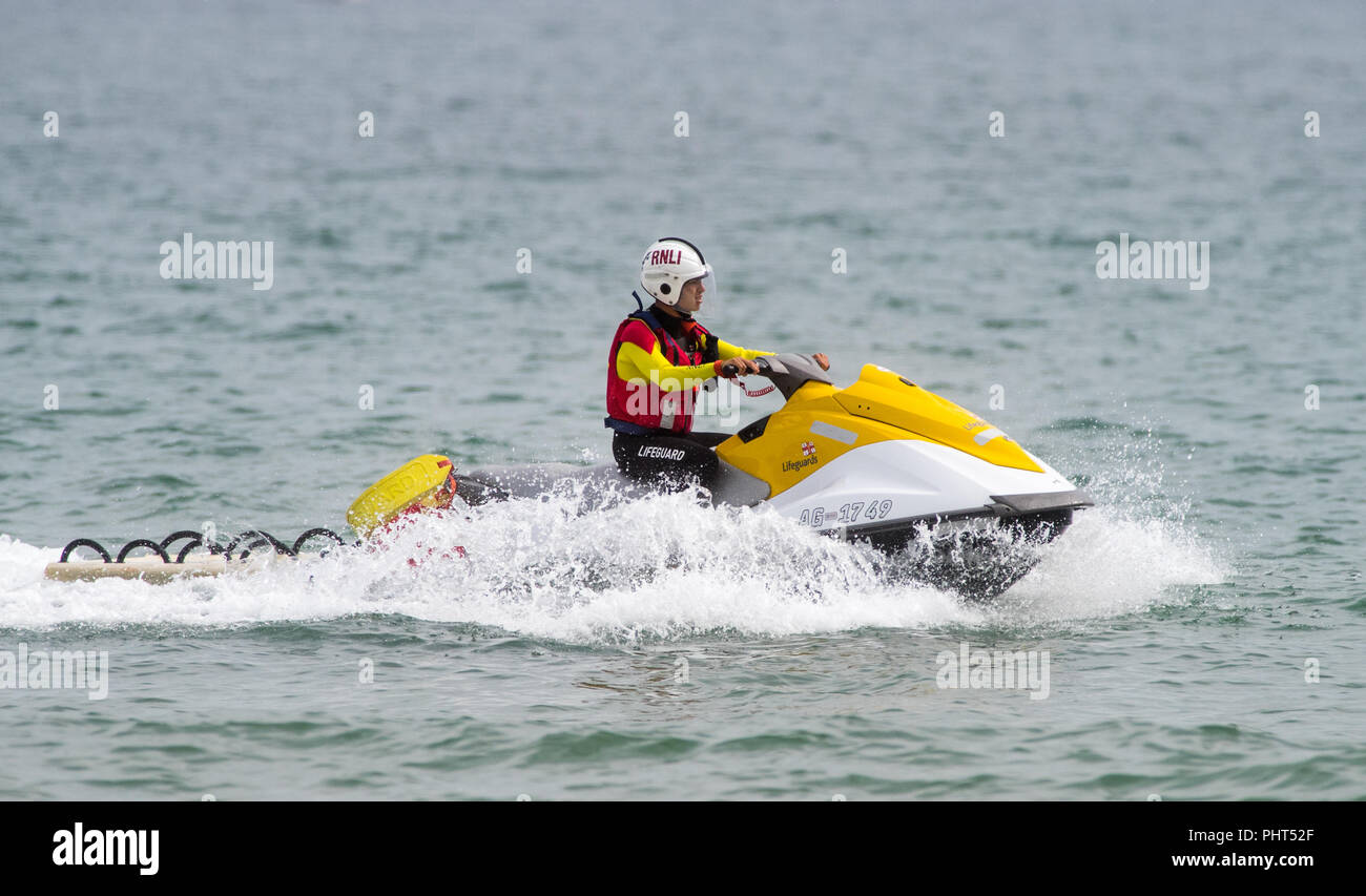 RNLI lifeguard on patrol at Bournemouth Beach in Dorset Stock Photo
