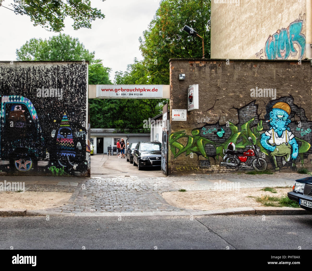 Berlin-Friederichshain.Carsystem Daniel Voss, used car dealer. Exterior  wall of business is covered in colourful street art Stock Photo - Alamy