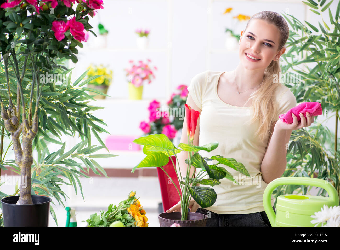 Young woman watering plants in her garden Stock Photo - Alamy