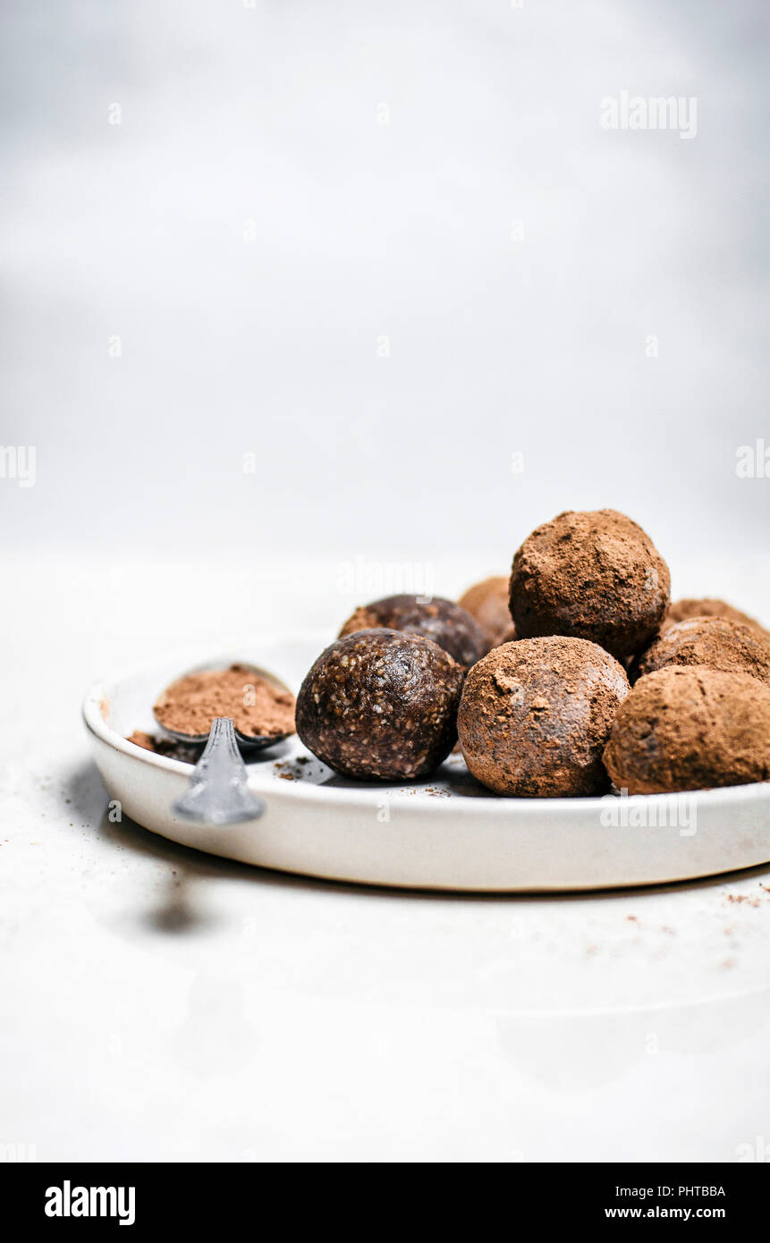 Chocolate hazelnut energy bites rolled in cocoa with white background