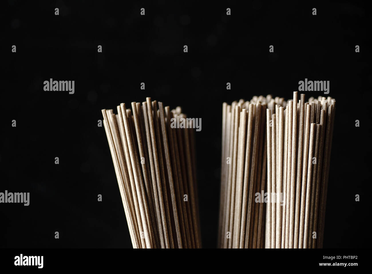 Close up of soba noodles, bamboo steamer and asian cuisine props on dark background Stock Photo