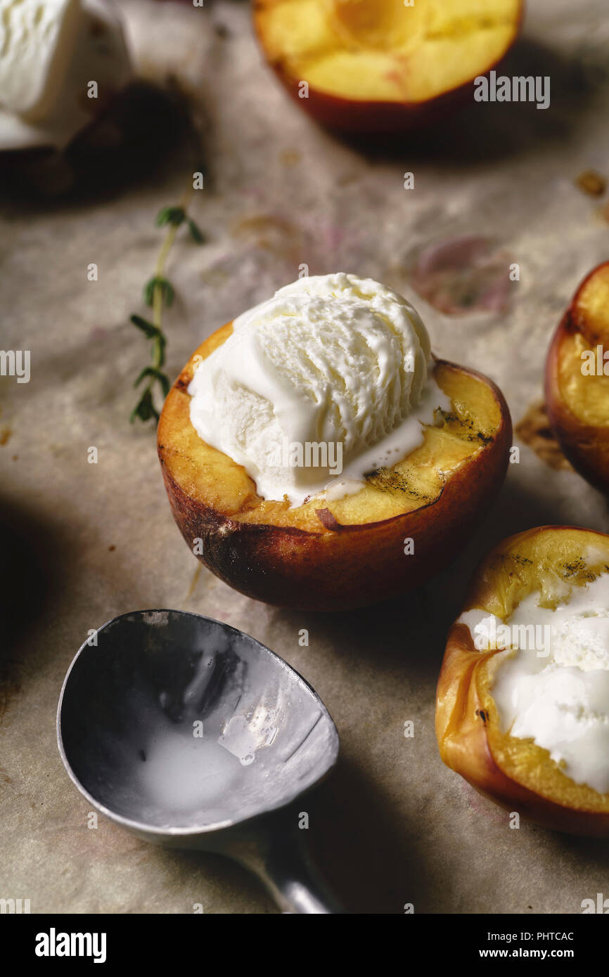 Melting vanilla ice cream served in hot grilled halved peaches and