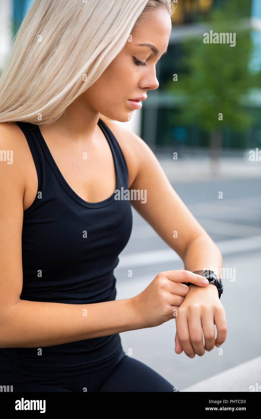 Confident Woman Checking Time On Smartwatch After Exercise Stock Photo