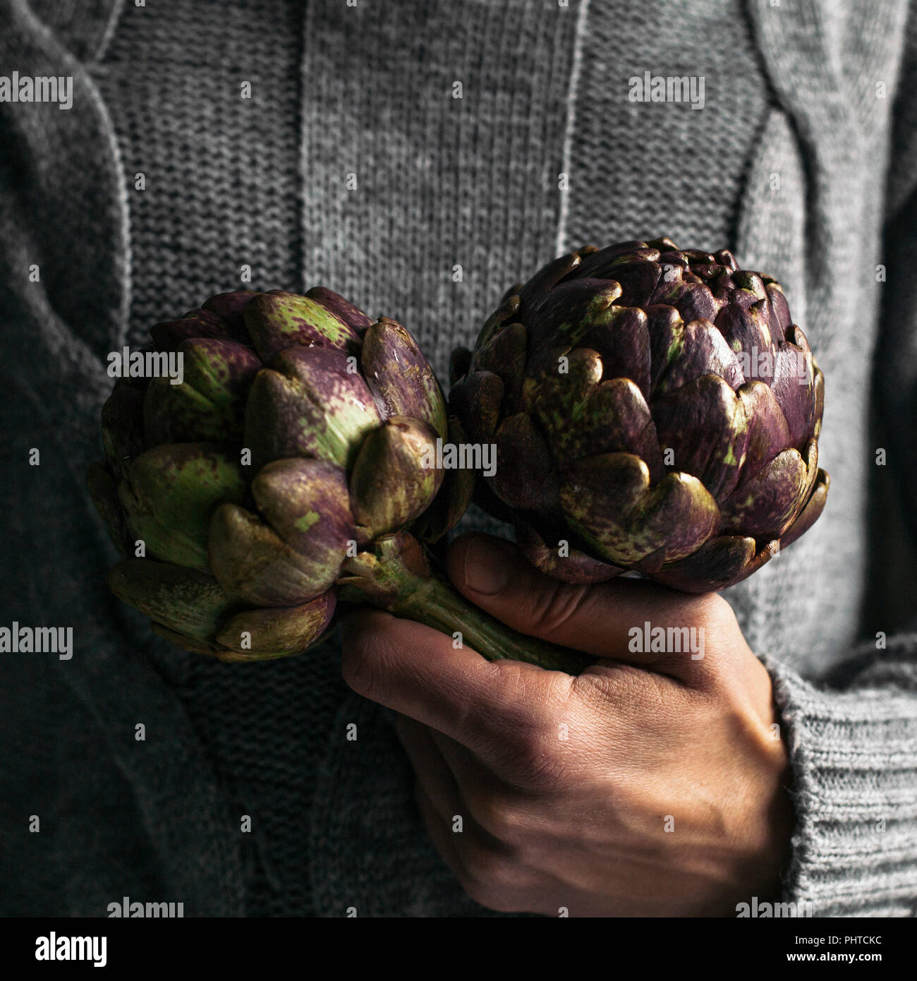 A man holding two artichokes Stock Photo
