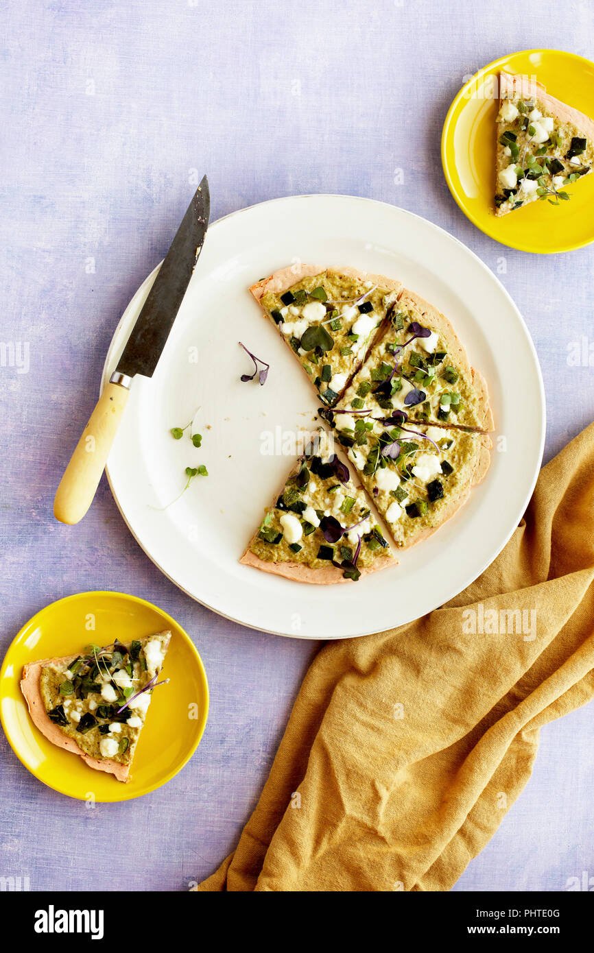 Red Lentil Flatbread with Roasted Poblano Tomatillo Pesto. Photographed on a lilac background. Stock Photo