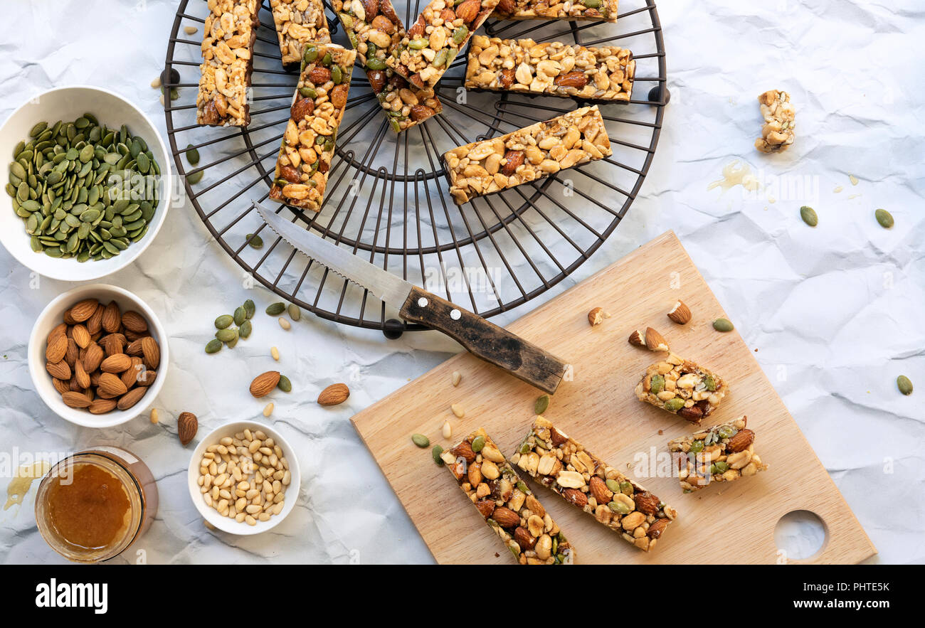 Honey nut bars with seeds and nuts in small bowls. Stock Photo