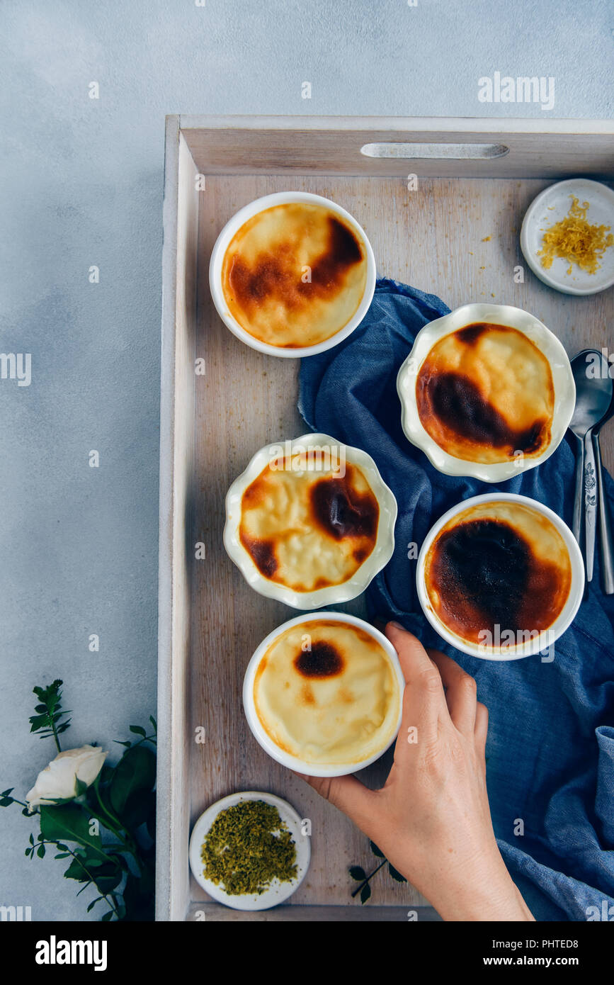 Creamy baked rice pudding in ramekins served in a wooden tray