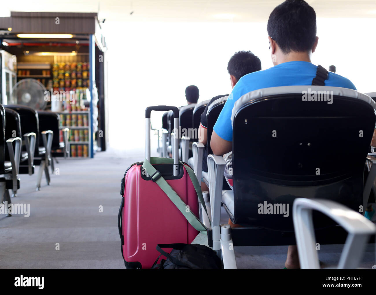 Passenger with luggage sitting waiting for the flight Stock Photo Alamy