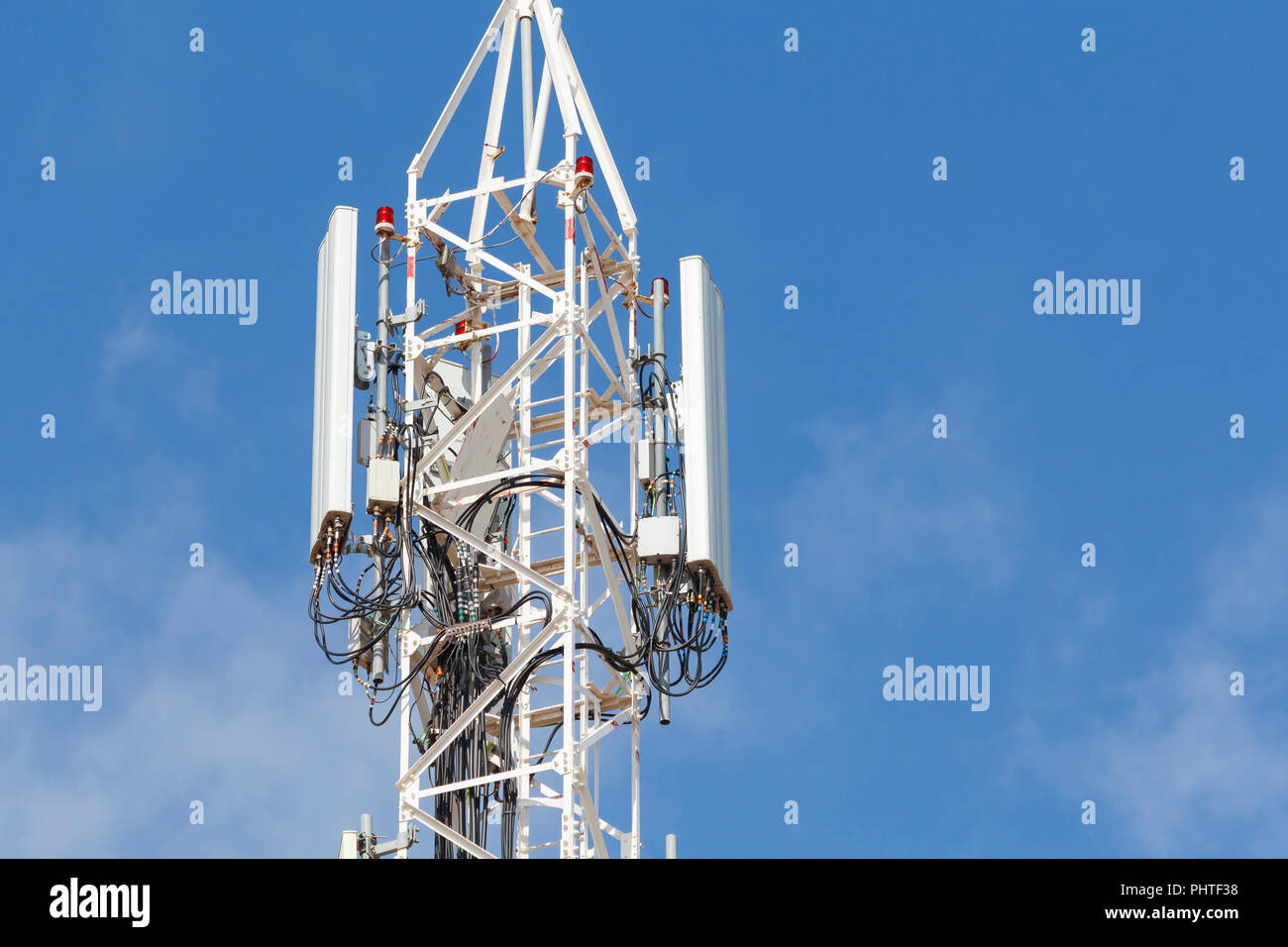Telecommunications tower against blue sky, with mobile antennas Stock Photo