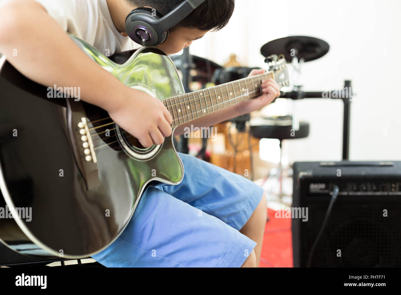 Boy playing a acoustic guitar with headphones Stock Photo Alamy