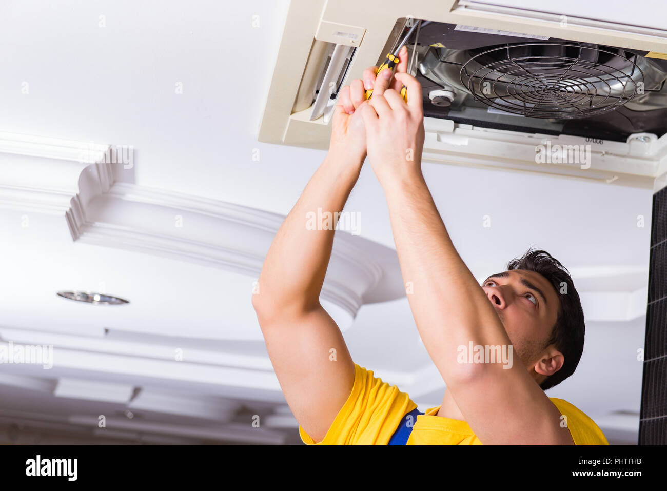 Repairman Repairing Ceiling Air Conditioning Unit Stock Photo