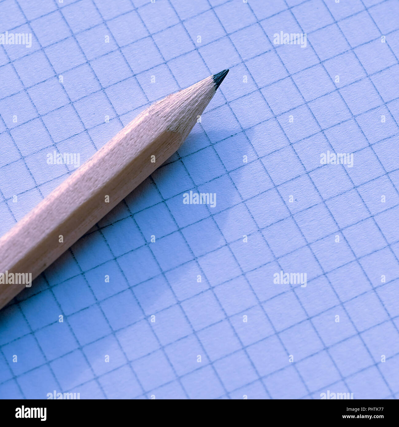 the pencil on the Notepad. Notebook sheet in a cage Stock Photo