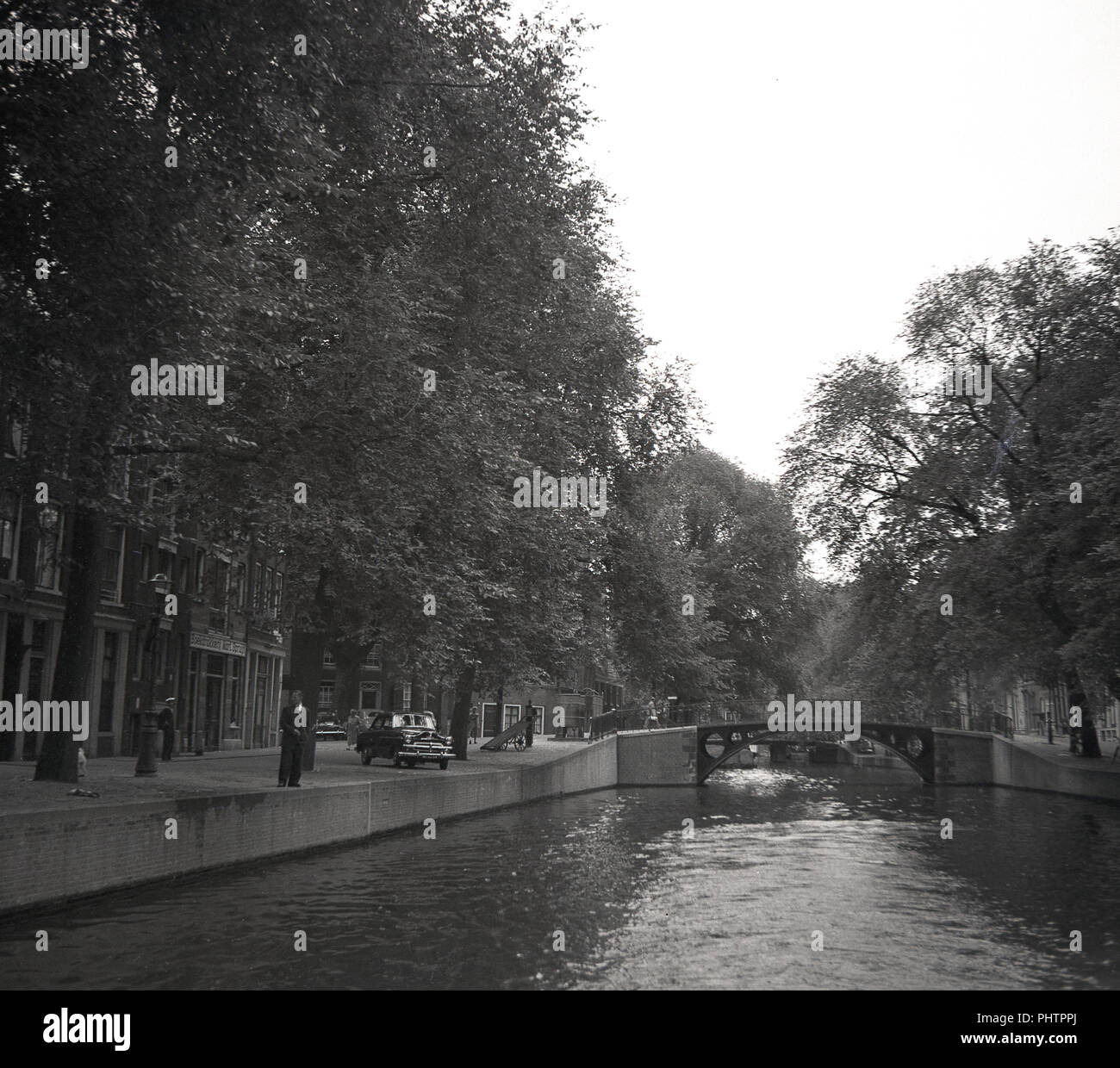 July, 1950, Amsterdam, a view in this era of one of the 165 canals in the city,The Netherands. in the distance, a bridge, of which there are 1281. Stock Photo