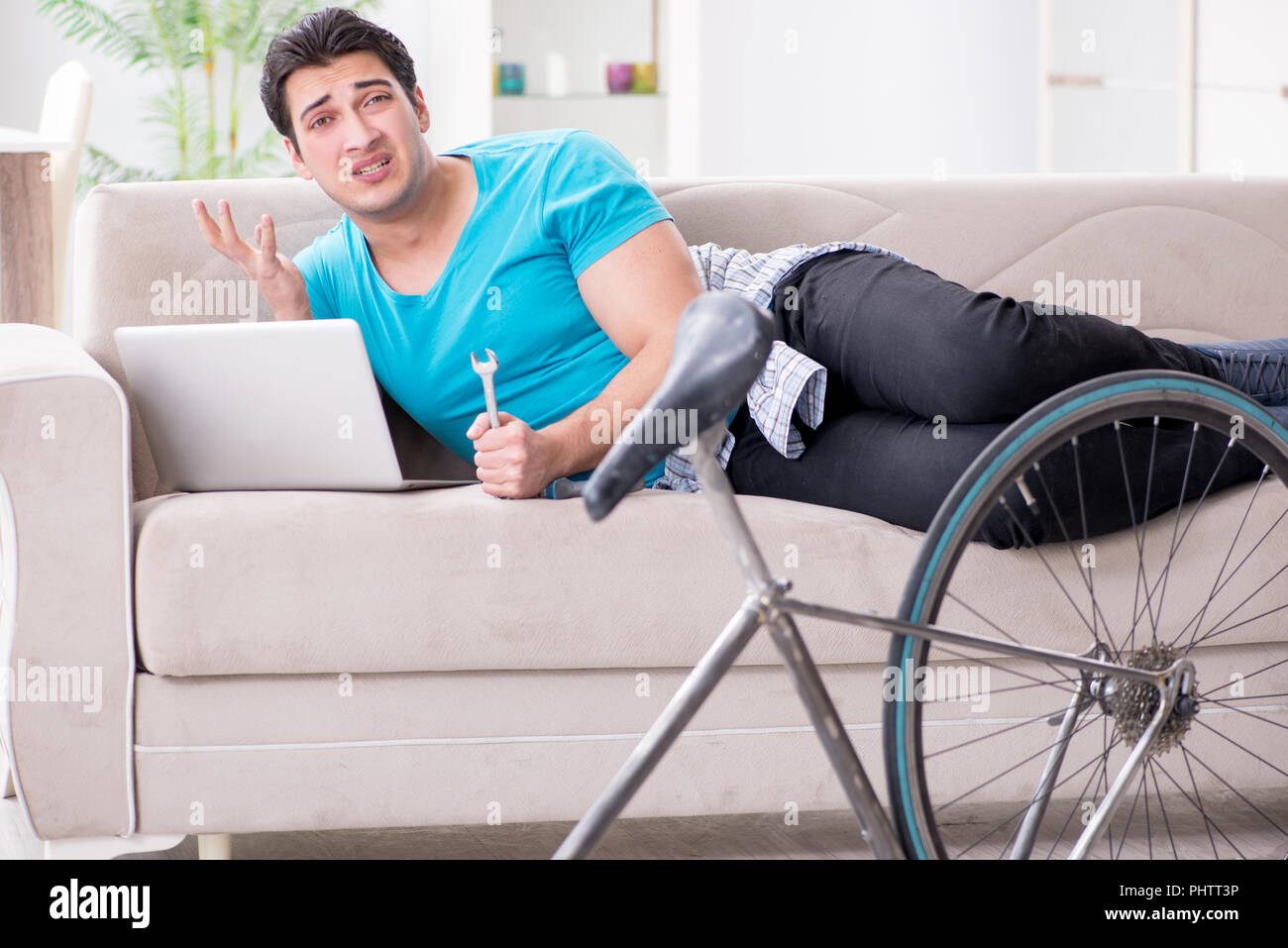 Young man repairing bicycle at home Stock Photo - Alamy