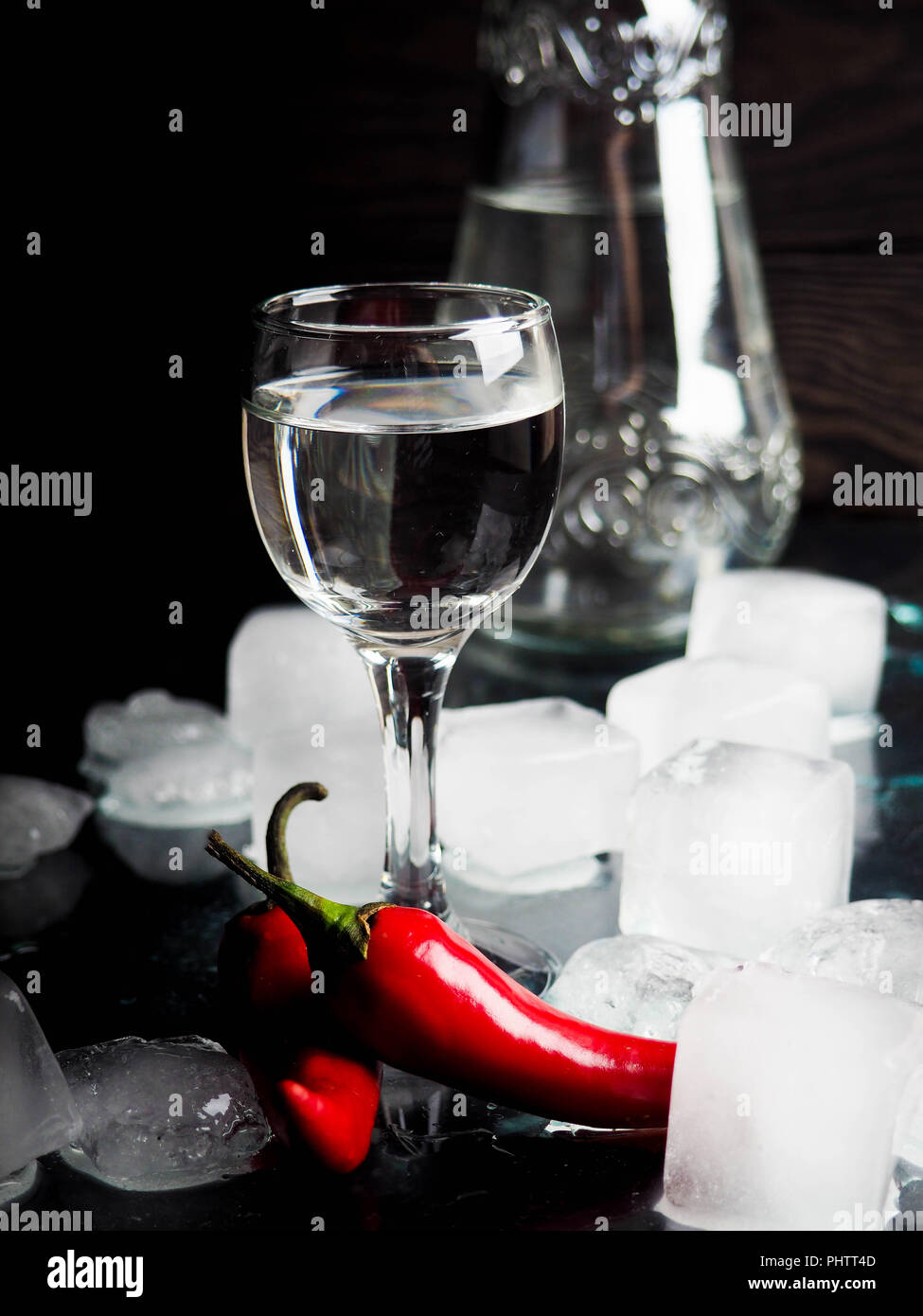 a shot of vodka, an alcoholic beverage, next to ice, fire, ice, red