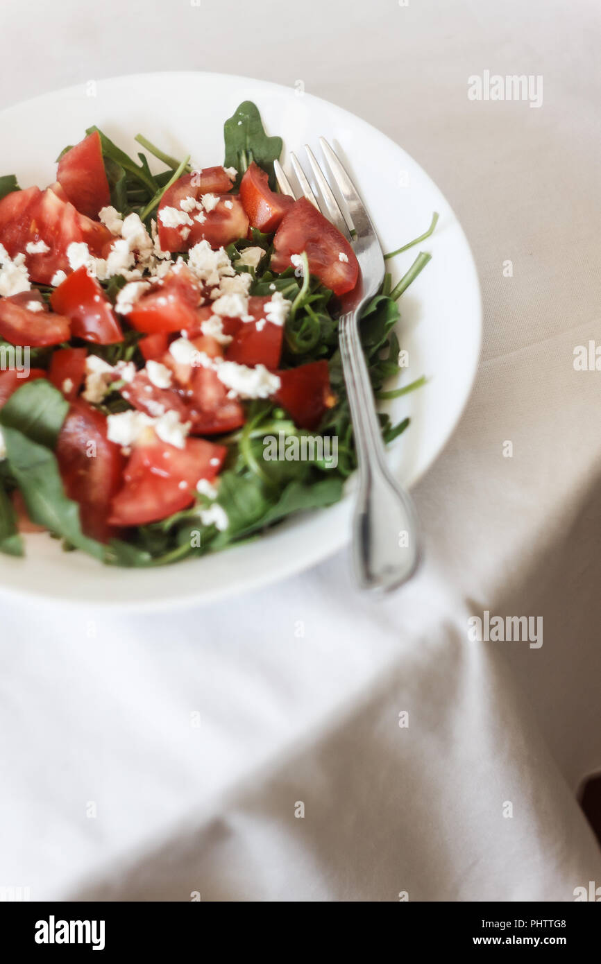 Tomato salad with basil, cheese, olive oil and garlic dressing on white